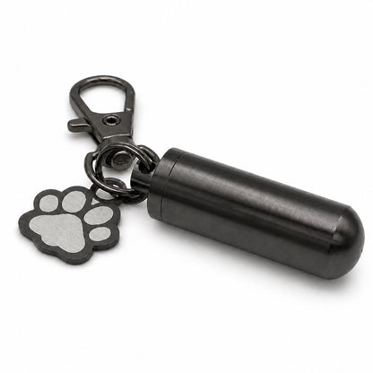 Vue 3/4 du porte-clés Empreinte du Souvenir urne en acier inoxydable noir avec pendentif patte et cylindre souvenir
