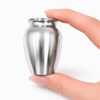 Urne du Souvenir Éternel argenté tenue en main, format compact et design sobre