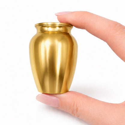 Urne du Souvenir Éternel doré tenue en main, format compact et design sobre